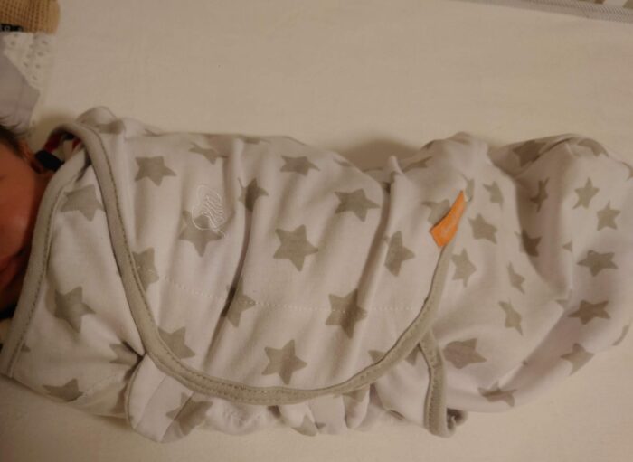 スワドルに包まれた新生児期の赤ちゃん