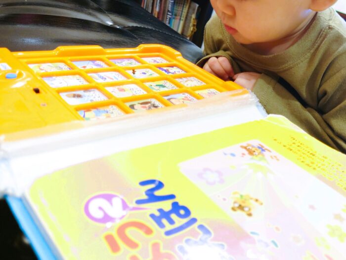絵本を眺める１歳０ヶ月の赤ちゃん
