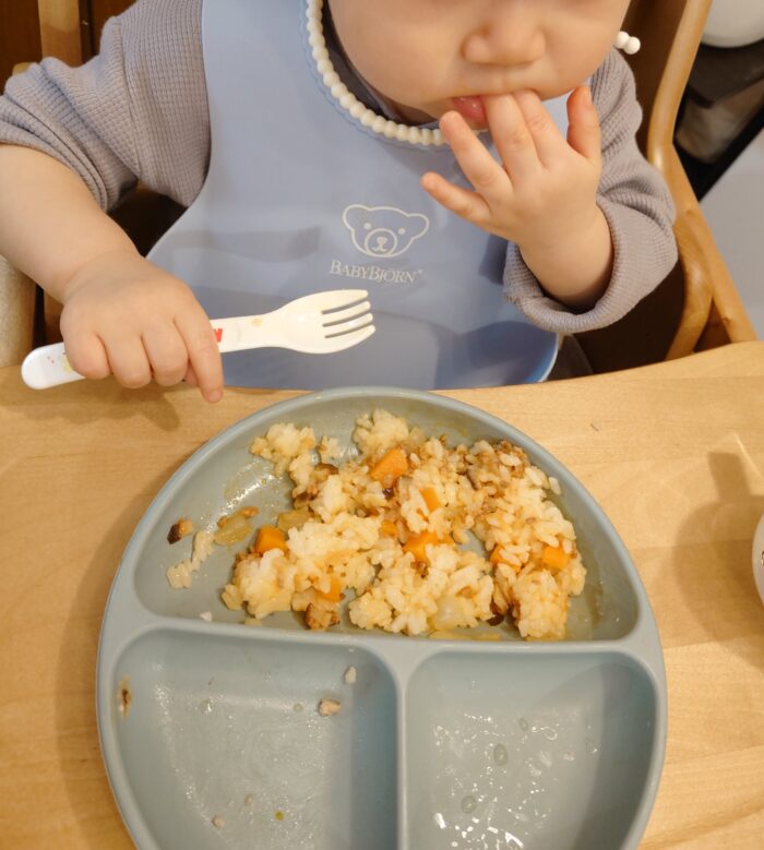１人でフォークを使ってご飯を食べる１歳１ヶ月の赤ちゃん