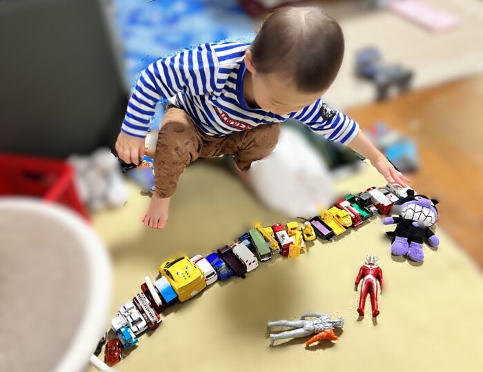 オモチャを横一列に並べる２歳１ヶ月の子供