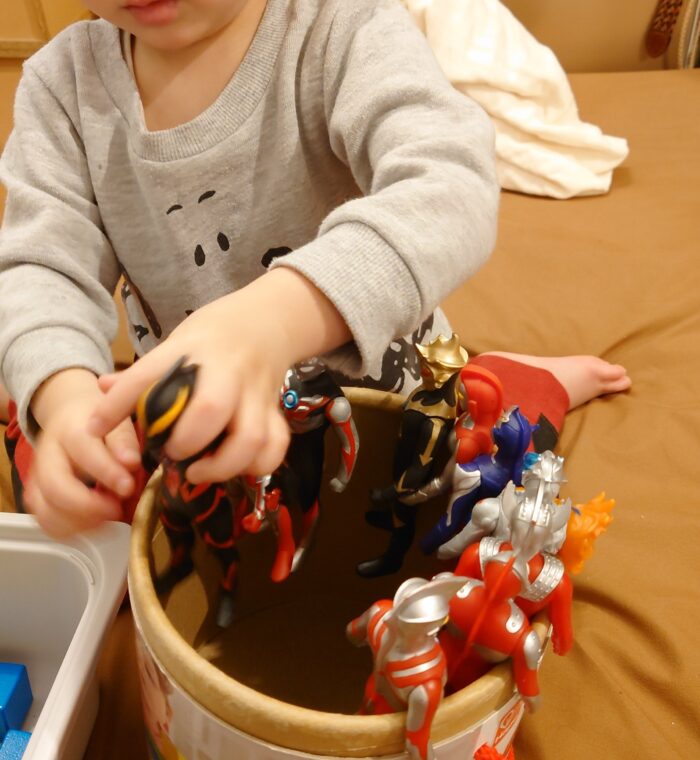 ウルトラマンの人形を布団に並べる2歳4ヶ月の子供