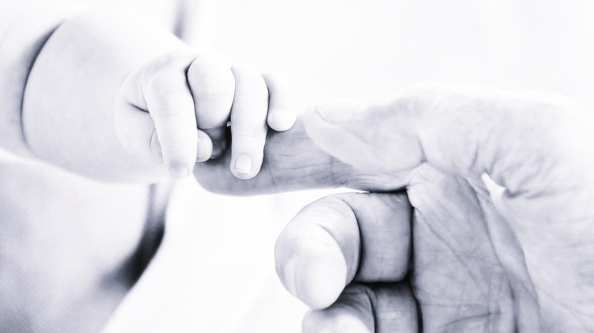 赤ちゃんの手を握る大人の手